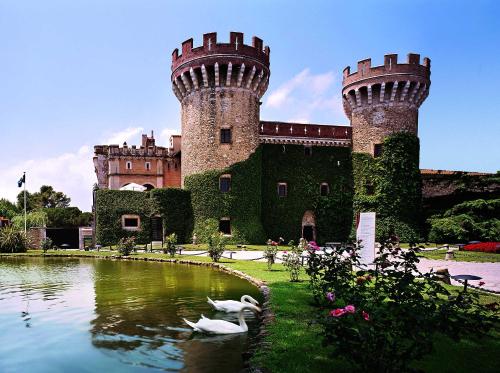 a castle with two towers and a pond with swans at Apartamento La Costa in Peralada