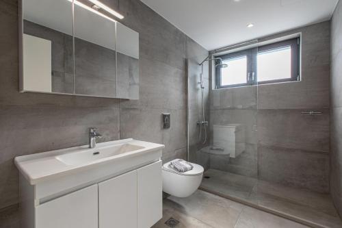 a bathroom with a sink and a toilet and a shower at Sage Villa by Vintage Travel in Tavronitis
