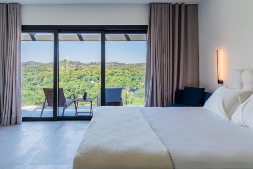 ein Schlafzimmer mit einem großen Bett und einem großen Fenster in der Unterkunft Zervos by Vintage Travel in Corfu