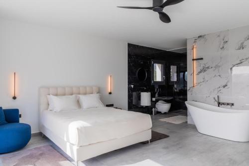 ein Schlafzimmer mit einem weißen Bett und einer Badewanne in der Unterkunft Zervos by Vintage Travel in Corfu