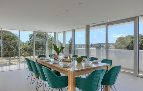 een eetkamer met een tafel en groene stoelen bij Villa Koko in Rovinj