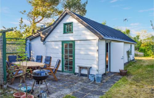 ein kleiner weißer Schuppen mit einem Tisch und einem Grill in der Unterkunft Pet Friendly Home In Beddingestrand in Beddinge Strand
