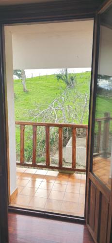 an open door to a balcony with a view of a yard at Matzuri Nekazal Turismoa in Mutriku