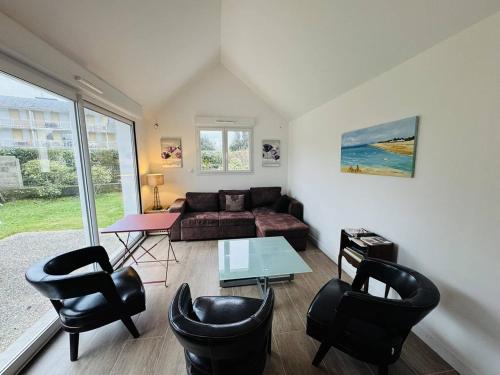 un salon avec un canapé, des chaises et une table dans l'établissement Maison plein centre ville, jardin clos, 500m plage, à Quiberon