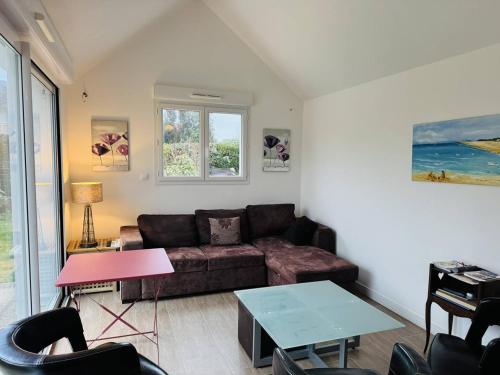 un salon avec un canapé et une table dans l'établissement Maison plein centre ville, jardin clos, 500m plage, à Quiberon