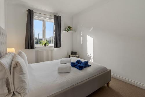 a bedroom with a bed with a blue bow on it at Quay Retreat - Short Stays UK Ltd in Exeter