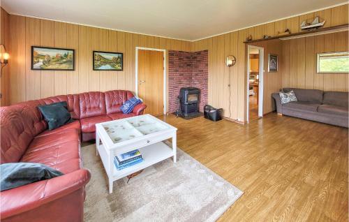 a living room with a red couch and a fireplace at Gorgeous Home In Reksteren With Kitchen in Hope