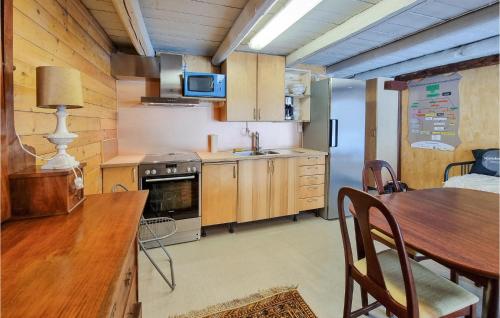 a kitchen with wooden cabinets and a table and a sink at Nice Apartment In Vedum With Wifi in Vedum