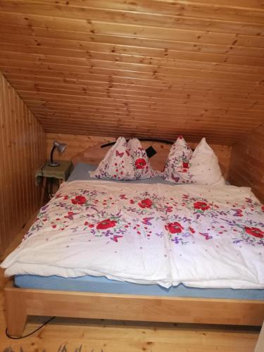 a bed with red flowers on it in a room at Ferienhaus 146 in Arnoldstein