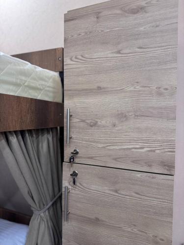a bedroom with a bed with a wooden wall at Hostel Old Alley in Tbilisi City