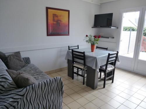 サルゾーにあるMaison Sarzeau-St Jacques - 100 m de la merのリビングルーム(テーブル、椅子、ソファ付)