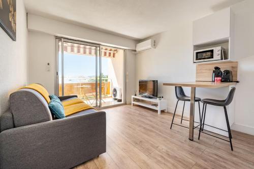 un salon avec un canapé et une table dans l'établissement Studio Le Dolce Vita - Fréjus Plage, à Fréjus