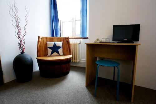 a room with a desk and a chair with a vase at Pension Alfa & Whisky Pub in Tábor