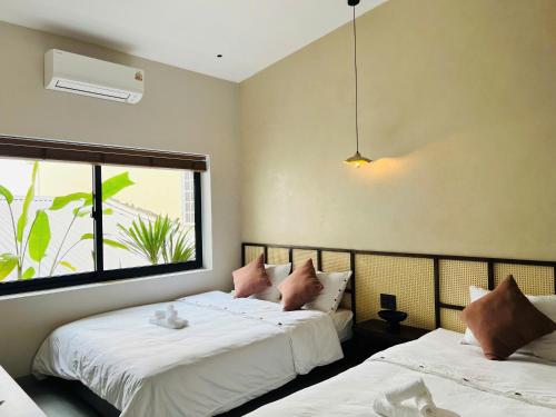 two beds in a room with a window at Ladyfit House in Thôn Trường Giang