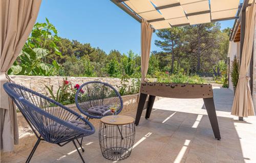 a patio with a ping pong table and chairs at 3 Bedroom Gorgeous Home In Jadrtovac in Jadrtovac