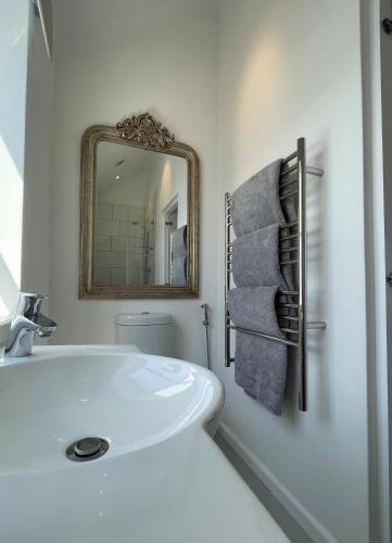 a bathroom with a white tub and a mirror at Thesen View - exquisite views with bikes & canoe in Knysna