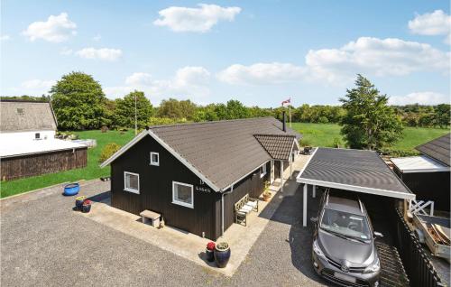 a black barn with a car parked in a parking lot at Beautiful Home In Millinge With Wifi in Millinge