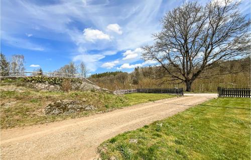 a dirt road with a fence and a tree at Lovely Home In Tving With Wifi in Tving