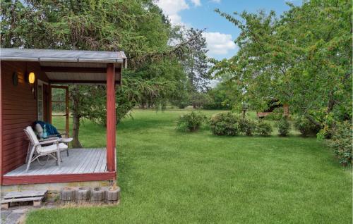 a wooden deck with a chair on a yard at Nice Home In Nykøbing Sj With Wifi in Klint