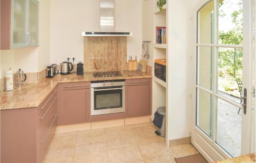 a kitchen with a stove top oven next to a window at Amazing Home In Saint Remy De Provence in Saint-Rémy-de-Provence