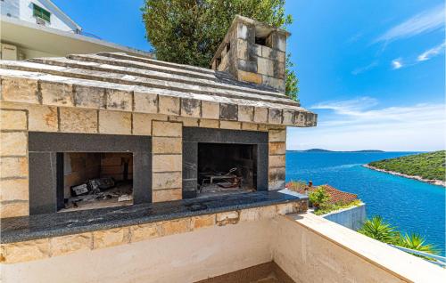 an outdoor brick fireplace with a view of the water at Gorgeous Home In Vinisce With Jacuzzi in Vinišće