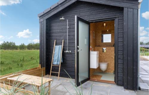 a black shed with a toilet and a chair at Stunning Home In Jerup With Wifi in Jerup