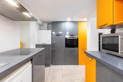 a kitchen with stainless steel appliances and yellow accents at Living the Green in Friedrichsdorf