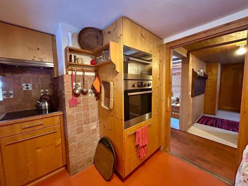 a kitchen with wooden cabinets and an oven in it at Rougemont Hideaway chalet by the river in Rougemont