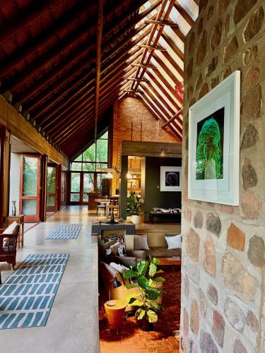 una gran sala de estar con una pared de piedra. en The Riverine Lodge, en Vaalwater