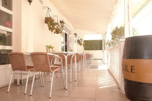 a row of chairs and a table in a restaurant at Hotel Josein in Comillas