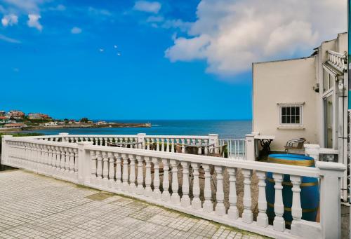 a white balcony with the ocean in the background at Hotel Josein in Comillas