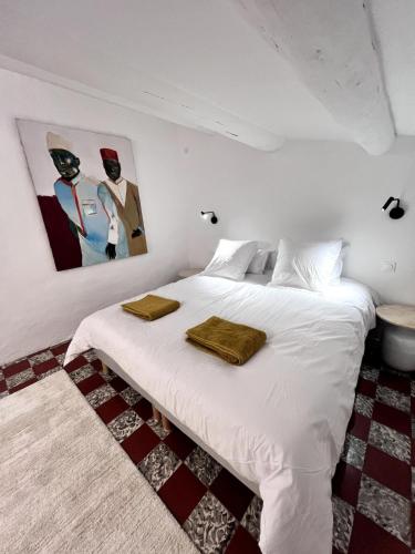une chambre avec un lit blanc avec deux serviettes dessus dans l'établissement Maison authentique centre historique, à Villeneuve-lès-Avignon