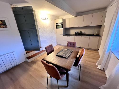 une cuisine et une salle à manger avec une table et des chaises en bois dans l'établissement Maison authentique centre historique, à Villeneuve-lès-Avignon