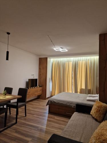 a bedroom with a bed and a table and a dining room at Kopaonik apartment A05 in Kopaonik