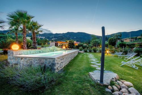 un patio trasero con una pared de piedra y una piscina en Entire Villa with Private Swimming Pool, en Rio Marina