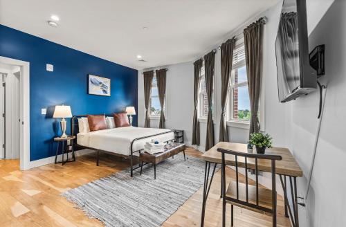 a bedroom with a bed and a blue wall at Furnished Apartment Near Logan Airport in Boston