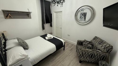 a bedroom with a bed and a chair and a mirror at Hotel 119 in Darlington