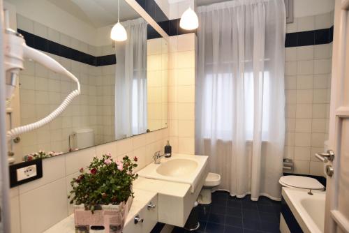 un bagno con lavandino, water e specchio di L'Agrifoglio Affittacamere a Gattinara