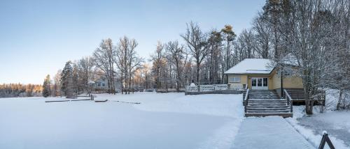 a yellow house with snow on it in a field at Nelijärve Holiday Centre in Aegviidu