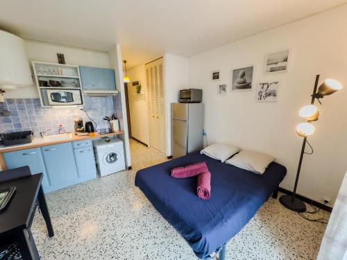 una piccola camera con letto blu in cucina di La petite frégate Studio idéal curiste a Balaruc-les-Bains