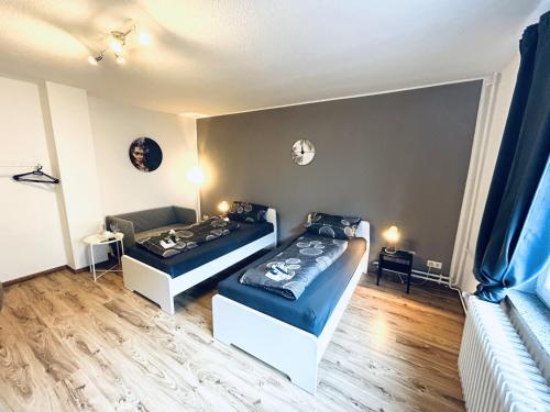 a bedroom with two beds and a couch at VAZ Apartments Work & Relax in Remscheid