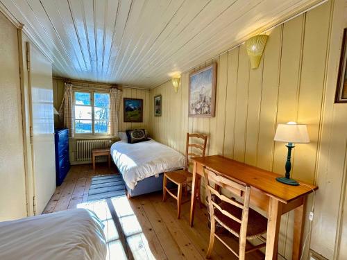 a bedroom with a desk and a bed and a table at 300 years old Chalet close to Center ski-lift in Chateau-d'Oex
