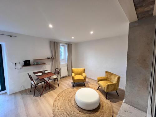 - un salon avec des chaises jaunes, une table et une table dans l'établissement Près d'Avignon, studio de charme avec vue, à Villeneuve-lès-Avignon