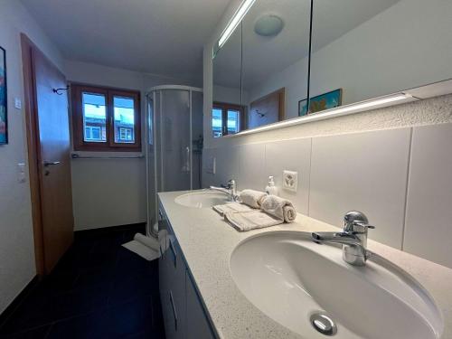 格施塔德Gstaad - Luxury Flat in Saanen的配有两个水槽和一面大镜子的浴室