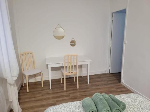 une salle à manger avec une table et deux chaises dans l'établissement La Parenthèse vous accueille, maison avec garage, à Saint-Quentin