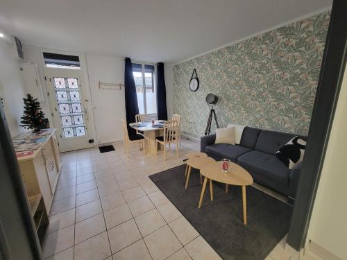 un salon avec un canapé et une table dans l'établissement La Parenthèse vous accueille, maison avec garage, à Saint-Quentin