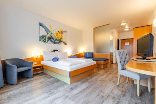 a hotel room with a bed and a desk at Hotel Xylophon - inklusive Thermeneintritte in Lutzmannsburg
