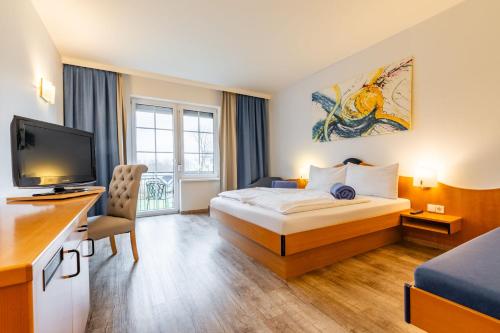 a hotel room with a bed and a flat screen tv at Hotel Xylophon - inklusive Thermeneintritte in Lutzmannsburg
