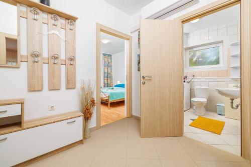 ein Bad mit einer Tür, die zu einem Schlafzimmer führt in der Unterkunft Apartments Pinty in Jadranovo