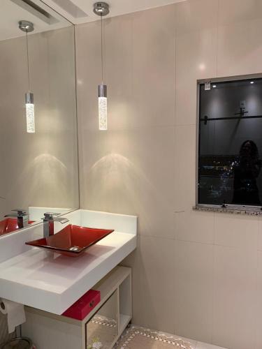 a bathroom with a red sink and a tv on the wall at Apartamento Duplex Cobertura in Belém